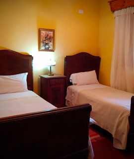 habitacion doble con camas y colores coloniales