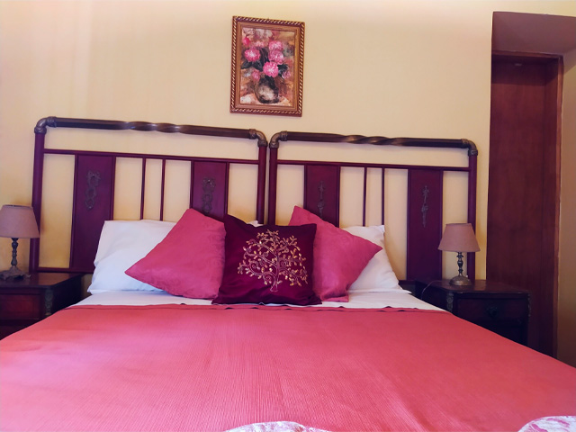 vestido de cama color salmón en un contexto de paredes crema y cuadros de flores